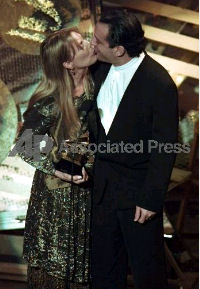Joni is kissed by Larry Klein after accepting the award.<br>Photo by Eric Draper. 