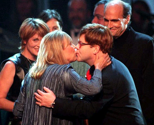 Elton John kisses Joni as singers Shawn Colvin and James Taylor look on.  Photo by Matt Campbell. 