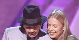 <i>And the Grammy goes to....</i><br>
Carlos Santana opens the envelope as Joni looks over his shoulder.