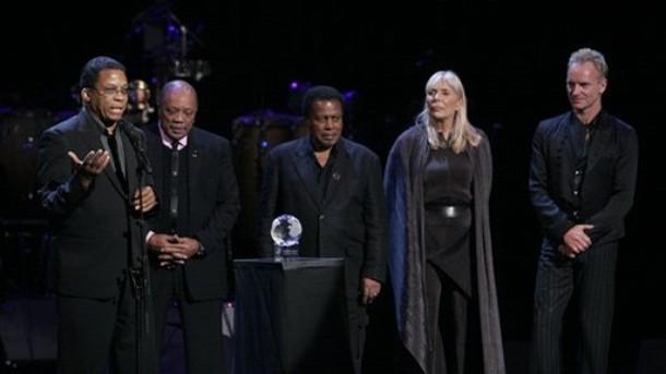 Herbie Hancock, accepts his humaitarian award as friends Quincy Jones, Wayne Shorter, Joni and Sting look on.