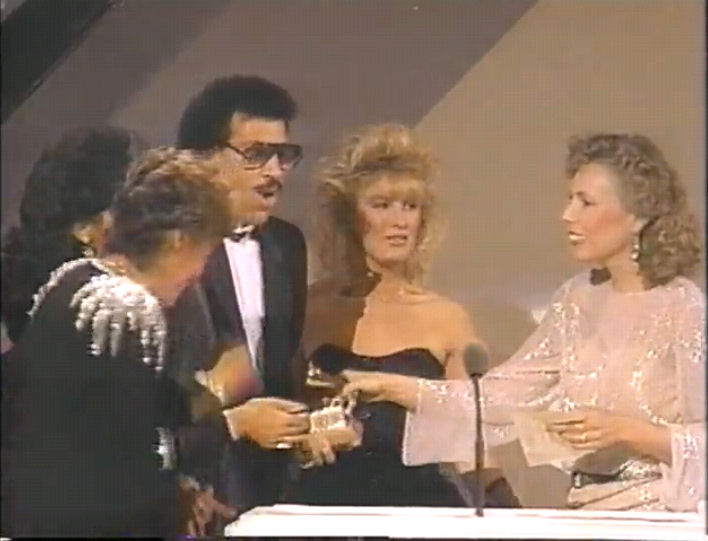 Joni presents Lionel with the Grammy.
