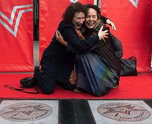 Author Margaret Atwood (left) and singer/songwriter Joni Mitchell hug after unveiling their stars in the Canada's Walk of Fame in Toronto on Friday Oct. 19, 2001. (CP PHOTO/Frank Gunn) 
